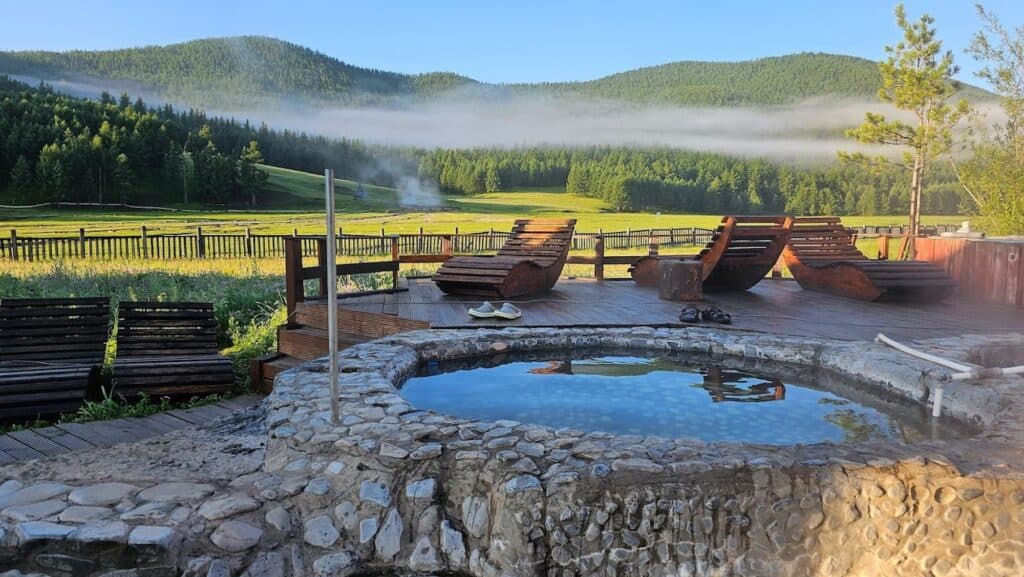 ينبوع ساخن في الهواء الطلق محاط بالمساحات الخضراء المورقة في منغوليا.