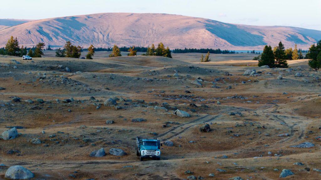 منظر طبيعي لوادي أورخون مع سيارة متوقفة، محاطة بسهول شاسعة وتلال بعيدة.