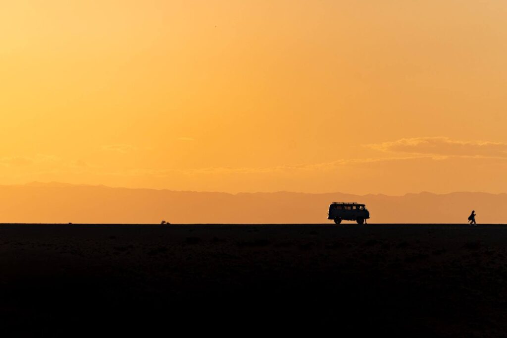 An outline of a Russian van on a flat landscape at the golden sunset.