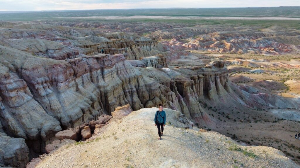 Woman walking on the top of White Stupa with all the pink cliffs in the background.