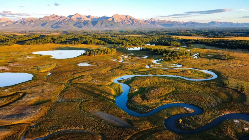 A winding river curls through the golden landscape of Northern Mongolia