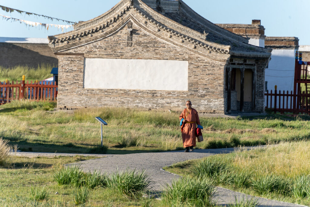 和尚走在草地上的小路上 